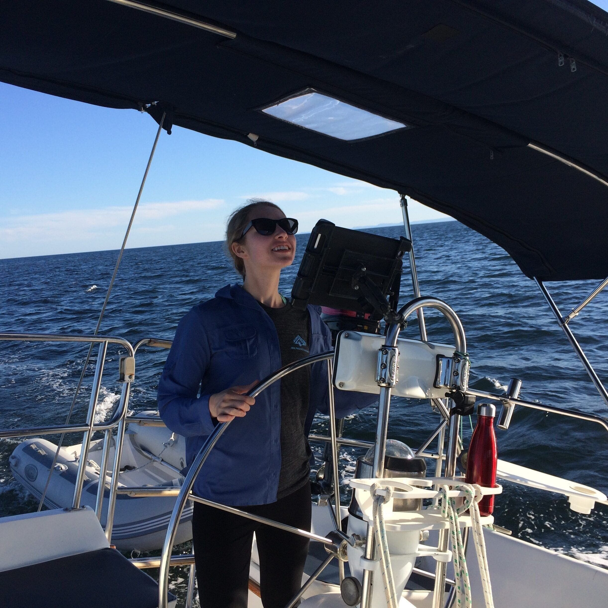 Delaney at the helm of a sailboat